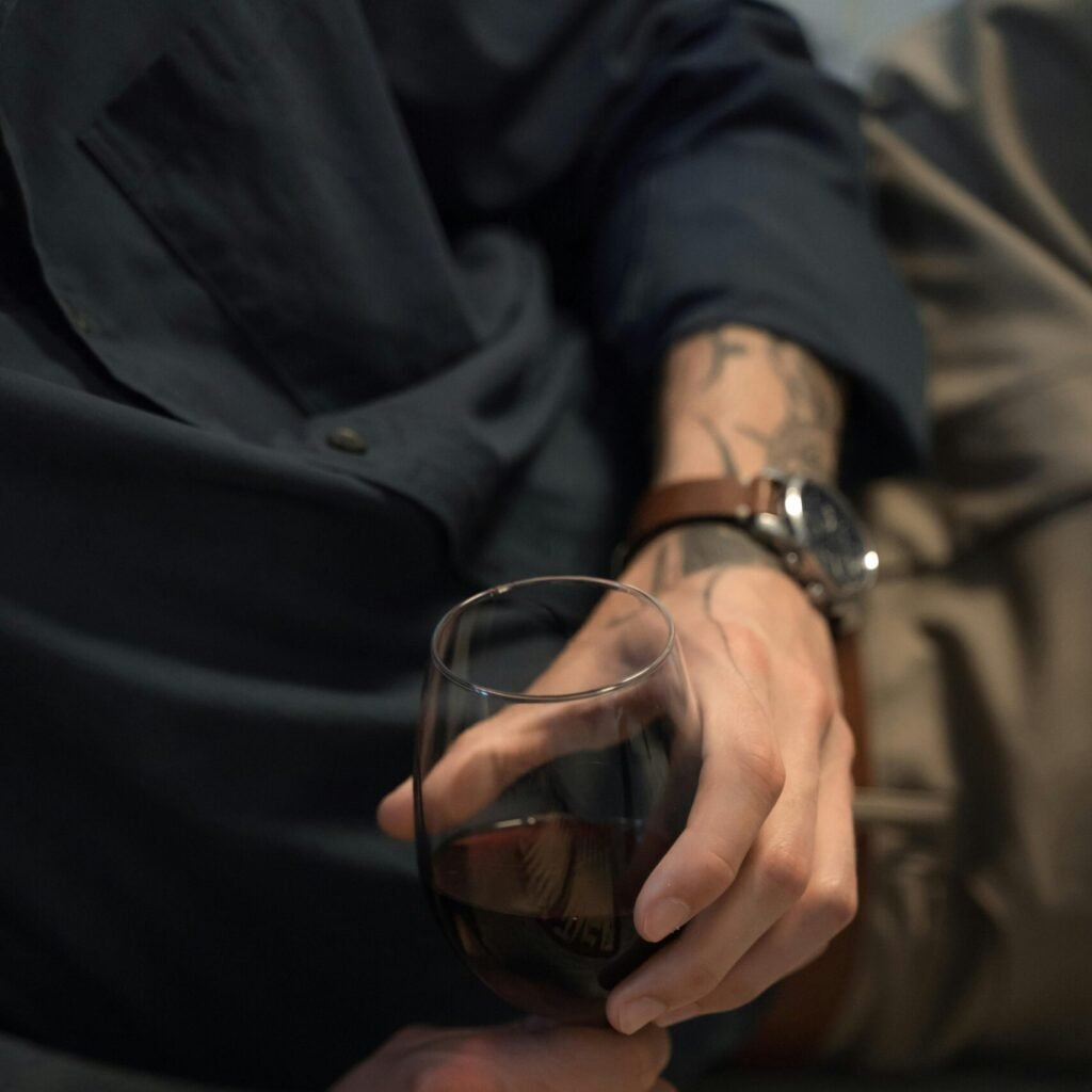 Homme montre avec verre de vin